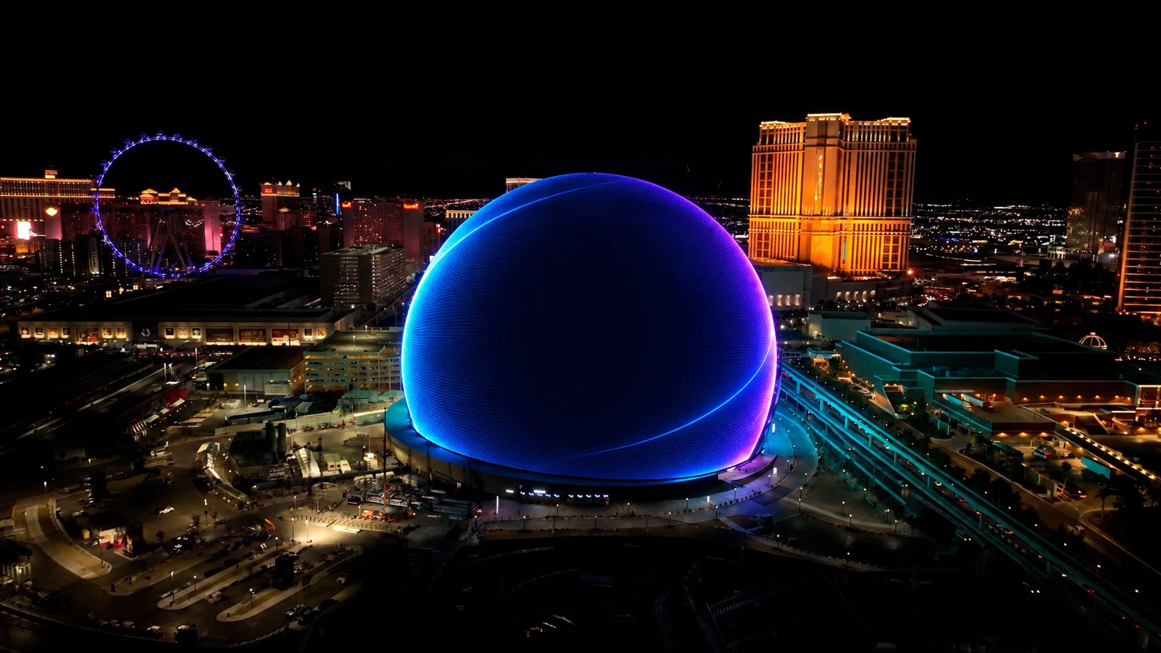 Creative concept of QuickWebX branding on Sphere, with the High Roller and illuminated Las Vegas hotels at night